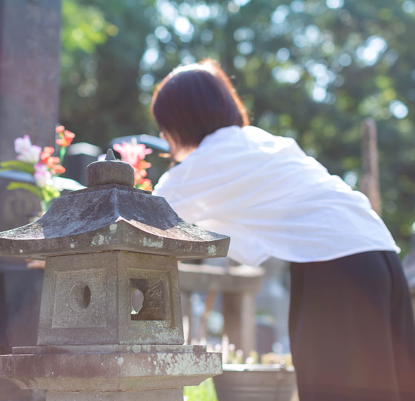 お墓を手入れする女性の写真